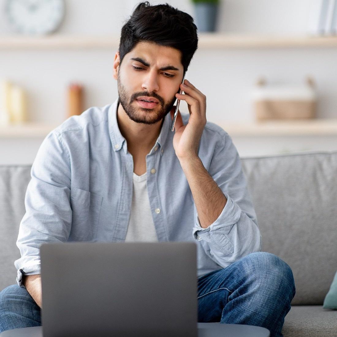 guy concerned on phone and laptop